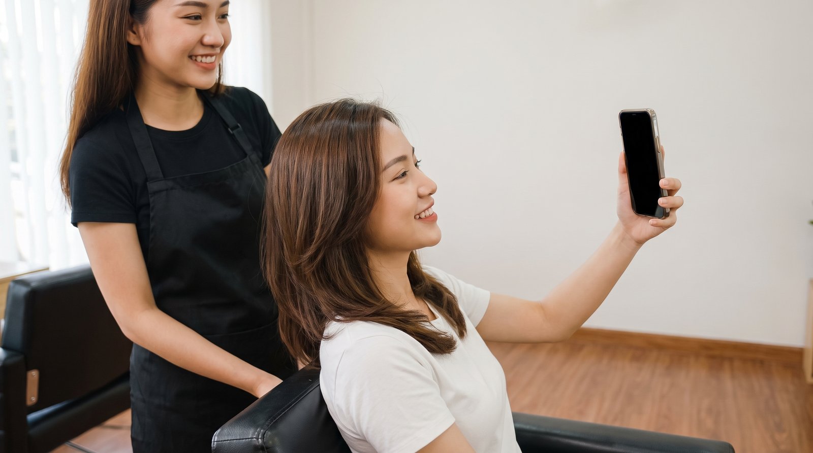 Khách nữ tự chụp ảnh mái tóc mới sau khi làm xong tại salon