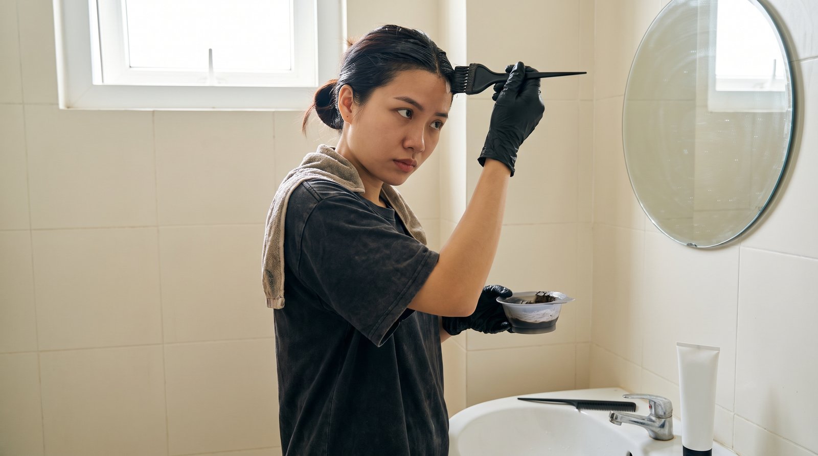 Cô gái tự nhuộm tóc tại nhà với cọ và chén thuốc nhuộm